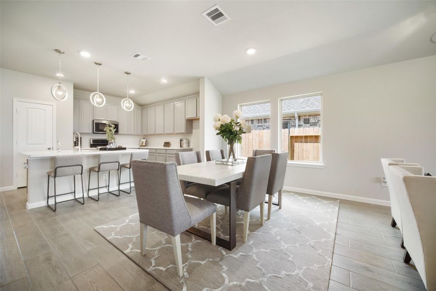Make memories gathered around the table with your family and friends! This spacious dining room features elegant flooring, custom paint, and adjacent to family room and kitchen for open concept feel. Sample photo of completed home with similar floor plan. Actual colors and selections may vary.