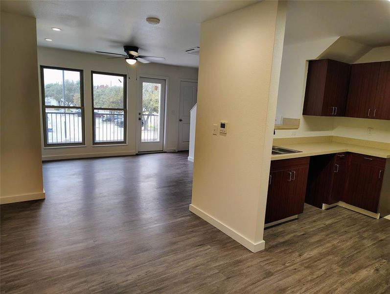 Kitchen with dark brown cabinetry, ceiling fan, dark hardwood / wood-style flooring, and a healthy amount of sunlight