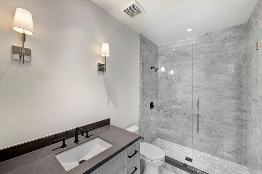 Ensuite bath with marble shower surround and floors.