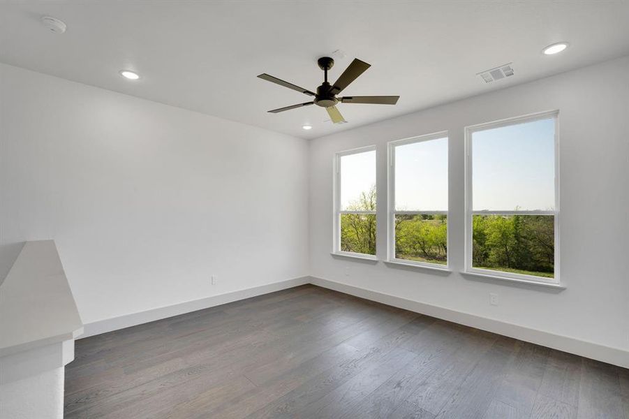 Empty room with dark wood-style floors, ceiling fan, and recessed lighting Empty room with dark wood-style floors, ceiling fan, and recessed lighting