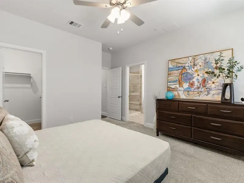 The primary suite is rounded out by an exceptionally deep, walk-in custom closet with plenty of hanging rods and cubby storage shelves.