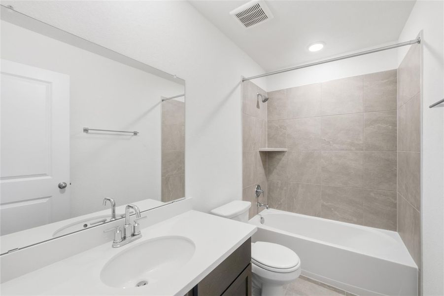 Full bathroom featuring tub / shower combination, vanity, and recessed lighting Full bathroom featuring tub / shower combination, vanity, and recessed lighting