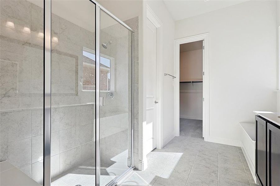 Bathroom featuring a shower with door and vanity