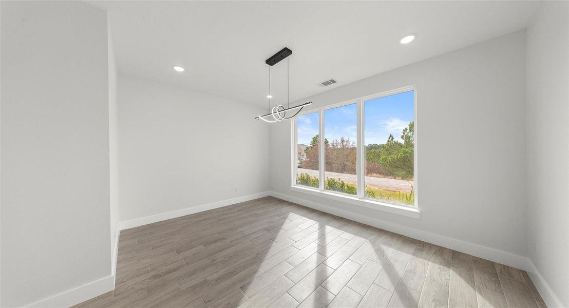 Unfurnished dining area featuring light wood-style floors, a chandelier, and recessed lighting