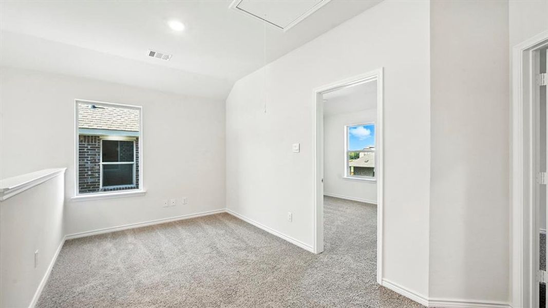 Empty room with attic access, light carpet, vaulted ceiling, and recessed lighting