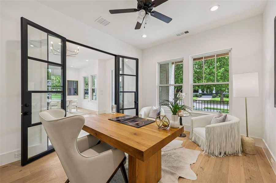 Light-filled room featuring wide plank wood-finish flooring and expansive double-hung windows