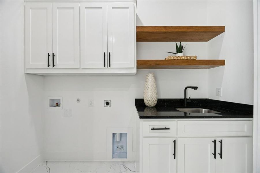 Laundry area featuring hookup for a gas dryer, hookup for an electric dryer, cabinet space, washer hookup, and light marble finish floors