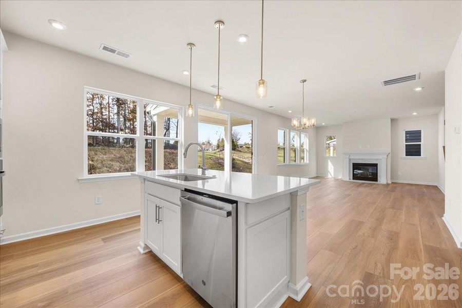 Large Central Island Featuring Quartz Countertops and Designer Pendant Lighting.