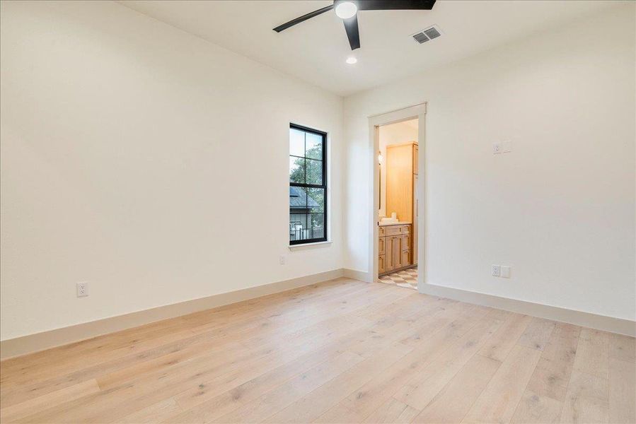 A quiet retreat with a functional ceiling fan and elegant light hardwood flooring.