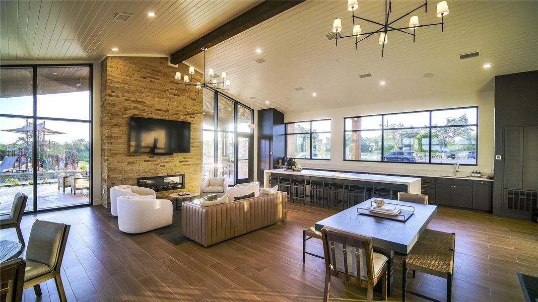 Living area with plenty of natural light, a chandelier, dark wood-style floors, expansive windows, and high vaulted ceiling Living area with plenty of natural light, a chandelier, dark wood-style floors, expansive windows, and high vaulted ceiling