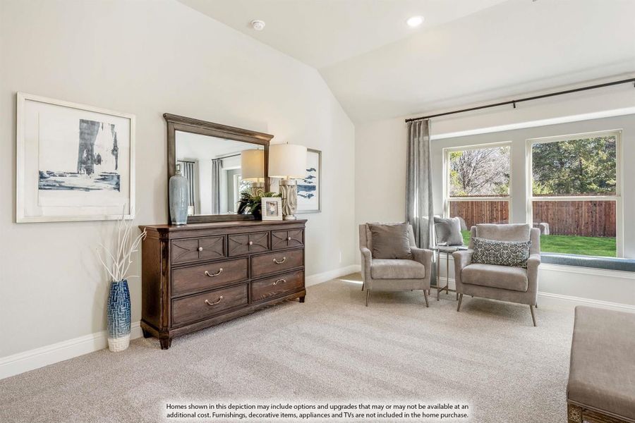 Bedroom with vaulted ceiling, dark wood dresser, two gray armchairs, and large windows with backyard view Bedroom with vaulted ceiling, dark wood dresser, two gray armchairs, and large windows with backyard view