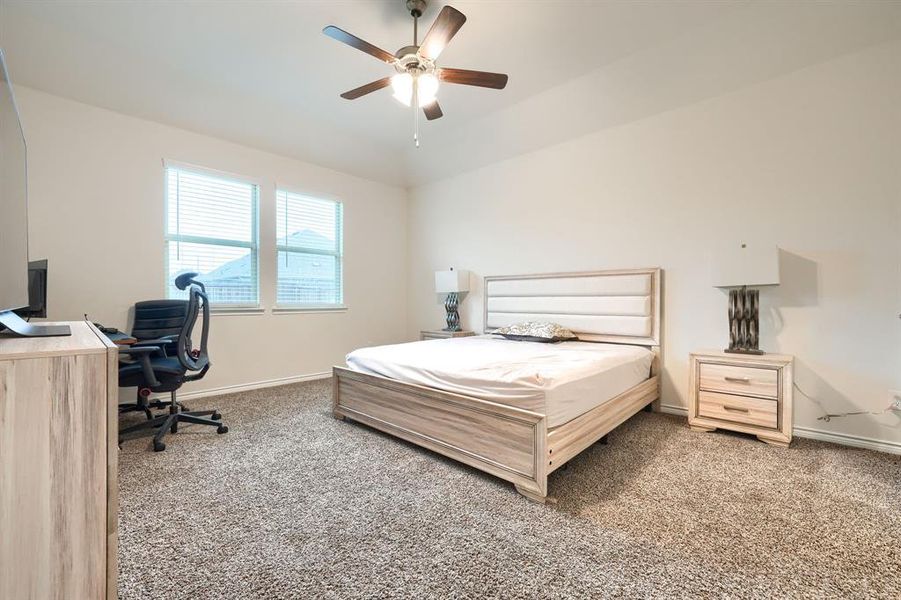 Bedroom with carpet flooring, a desk, and ceiling fan Bedroom with carpet flooring, a desk, and ceiling fan