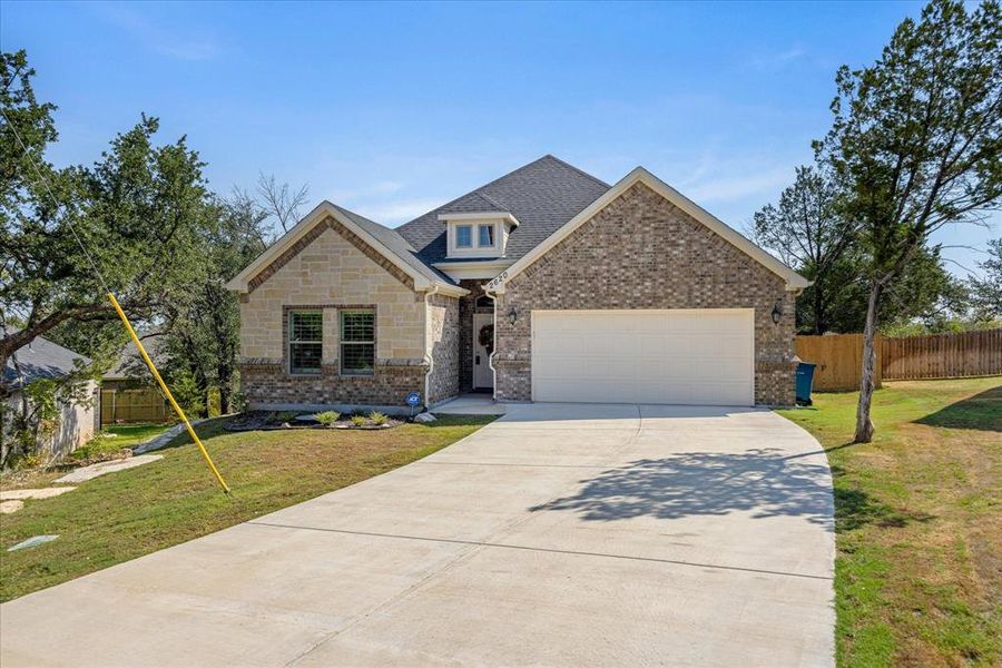 View of front facade with driveway, an attached garage, brick siding, and a shingled roof View of front facade with driveway, an attached garage, brick siding, and a shingled roof