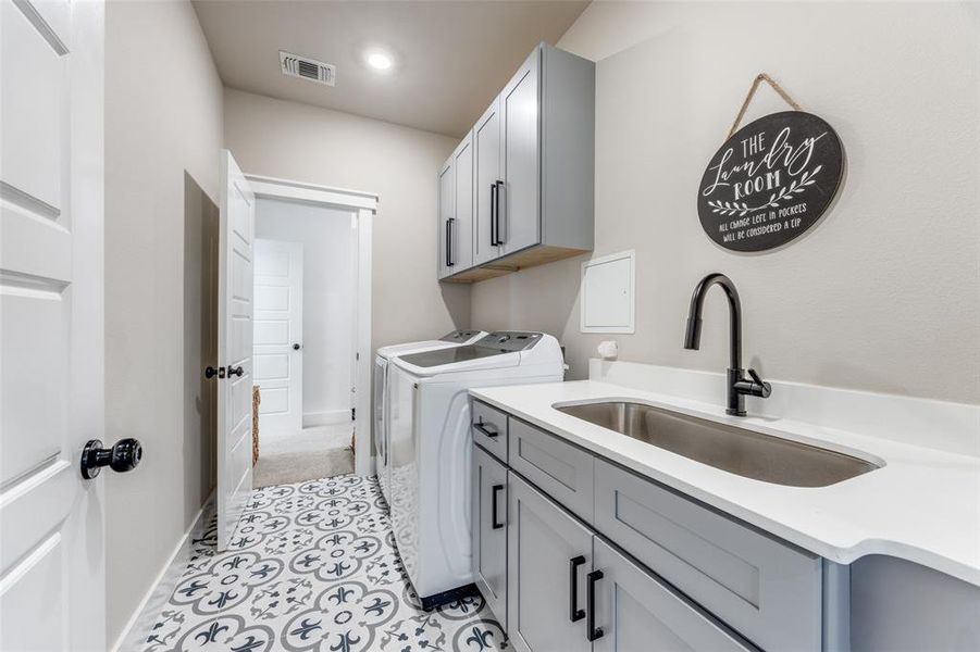 Laundry area featuring cabinet space, separate washer and dryer, and light tile patterned floors