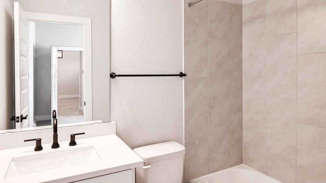 Full bath featuring vanity, shower / bath combination, and a textured wall