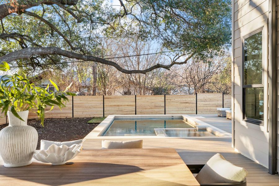 Wooden deck with a fenced backyard and a jacuzzi