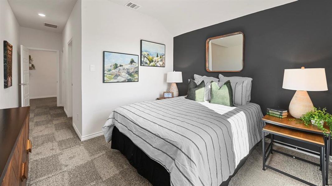 Carpeted bedroom with vaulted ceiling and baseboards