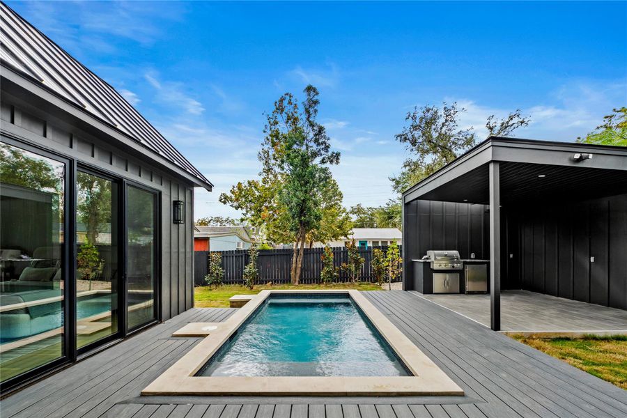 View of swimming pool featuring a patio and a wooden deck