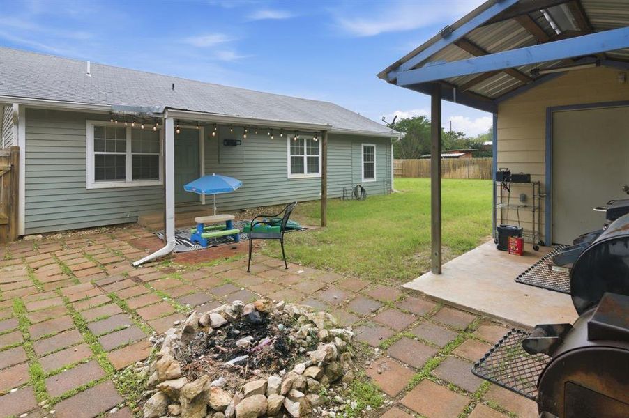 Expansive brick patio featuring a built-in fire pit