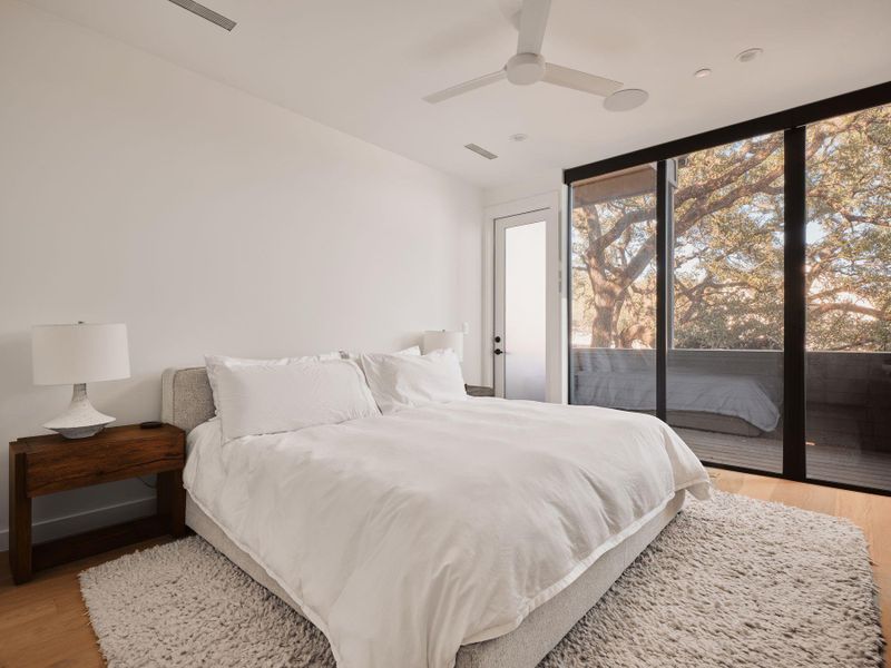 Bedroom with access to outside, light wood finished floors, and a ceiling fan