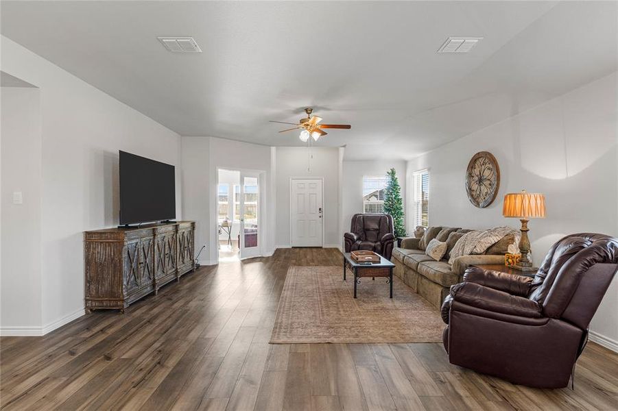 Living room with a ceiling fan and dark wood finished floors