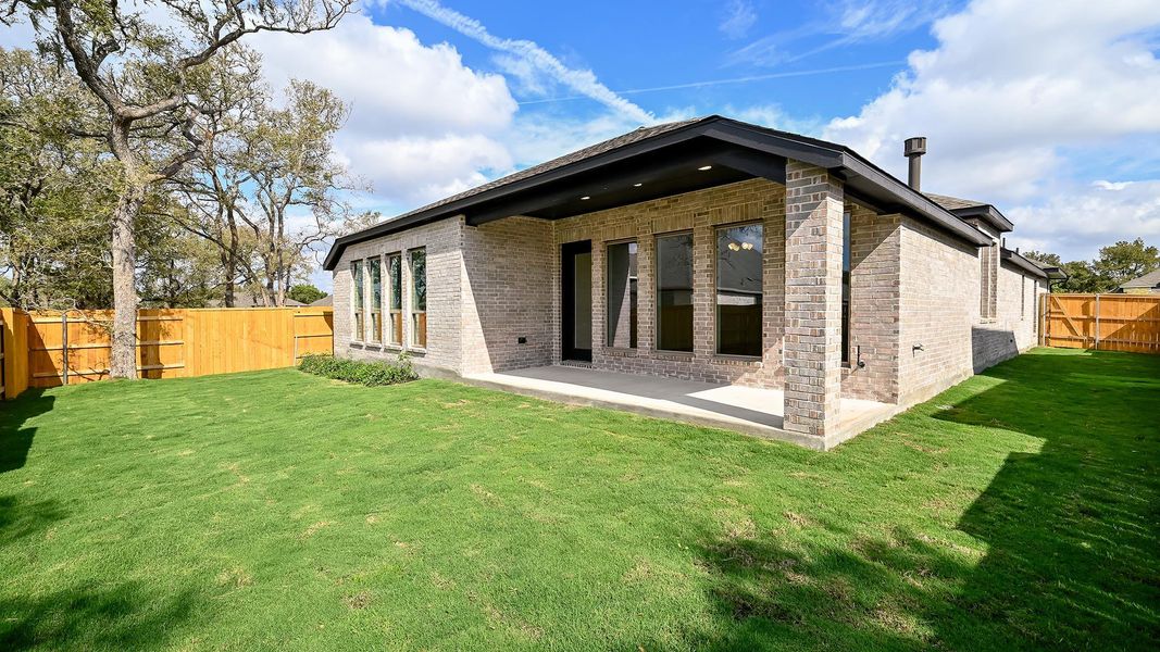 Back of house with a fenced backyard, a patio area, and brick siding Back of house with a fenced backyard, a patio area, and brick siding
