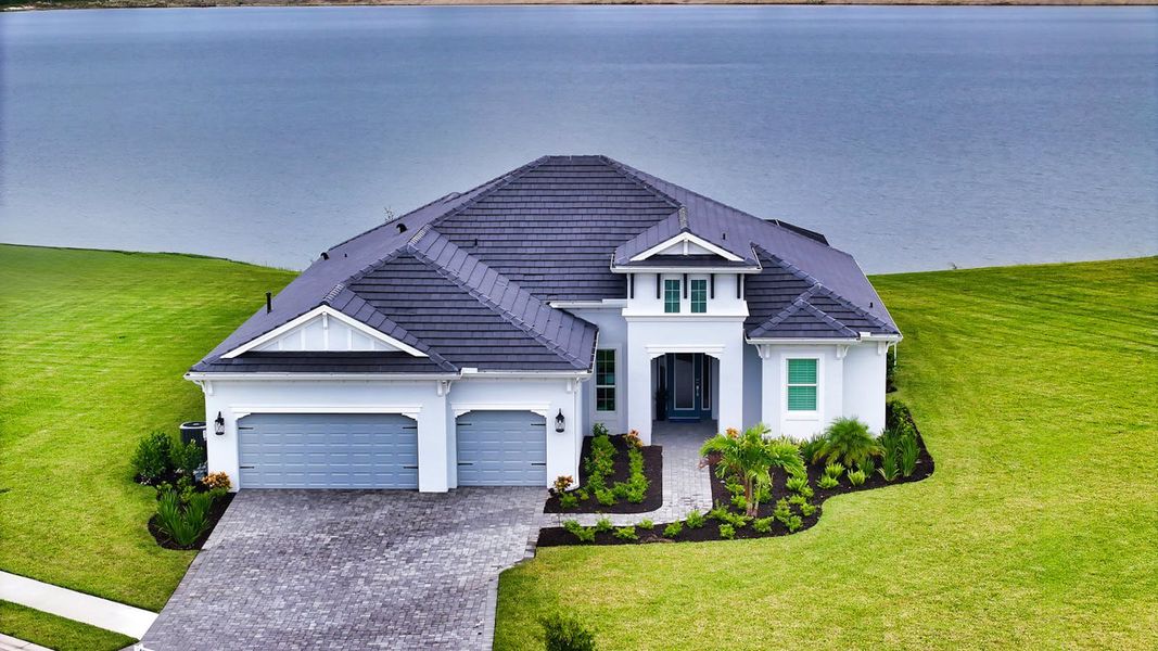 Front exterior of a new home in SkySail Real Estate and Homes for Sale in Naples, FL - Neal Communities, Naples, FL, highlighting curb appeal (Image 1). Front exterior of a new home in SkySail Real Estate and Homes for Sale in Naples, FL - Neal Communities, Naples, FL, highlighting curb appeal (Image 1).