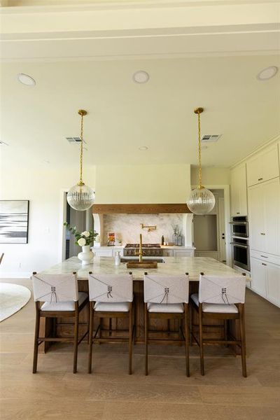 Kitchen island featuring a substantial countertop, under-counter storage, and seating for four