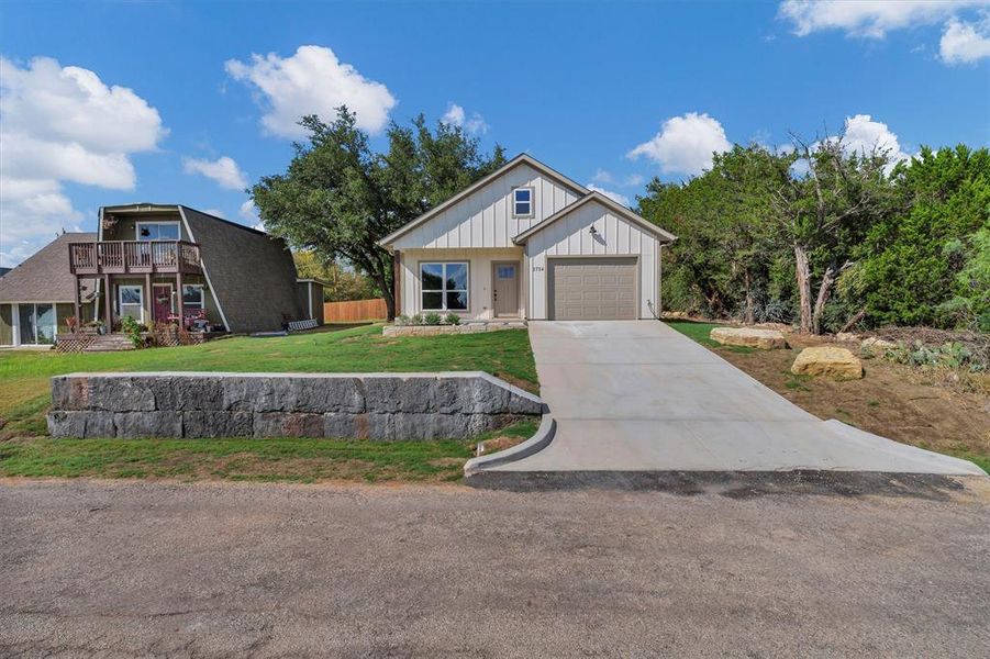 Modern farmhouse featuring board and batten siding, driveway, and a front yard Modern farmhouse featuring board and batten siding, driveway, and a front yard