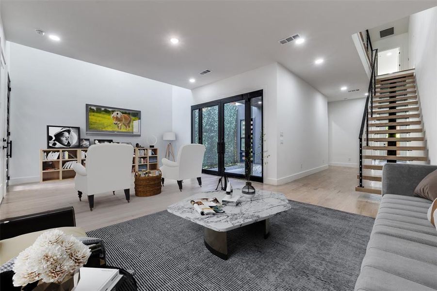 Living area with stairway, light wood-style flooring, and recessed lighting