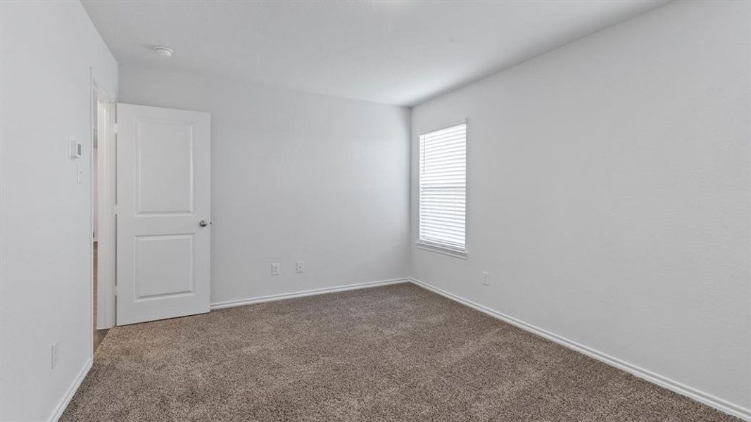 Spare room with dark carpet and baseboards