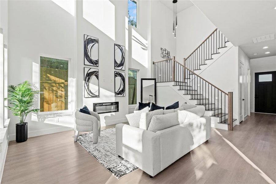 Living area featuring wood finished floors, a high ceiling, and stairway