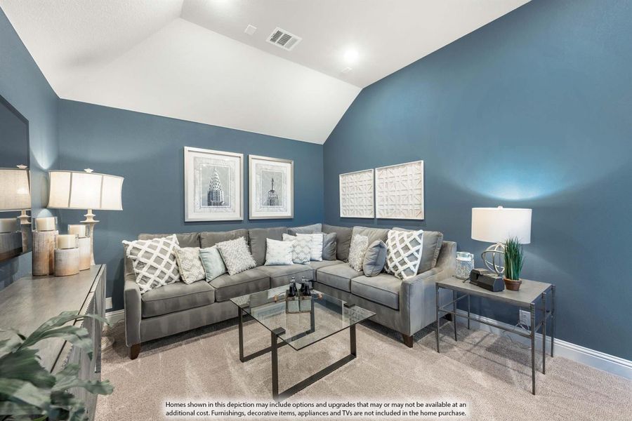 Living room with vaulted ceiling, blue walls, gray sectional sofa, and glass coffee table on carpet