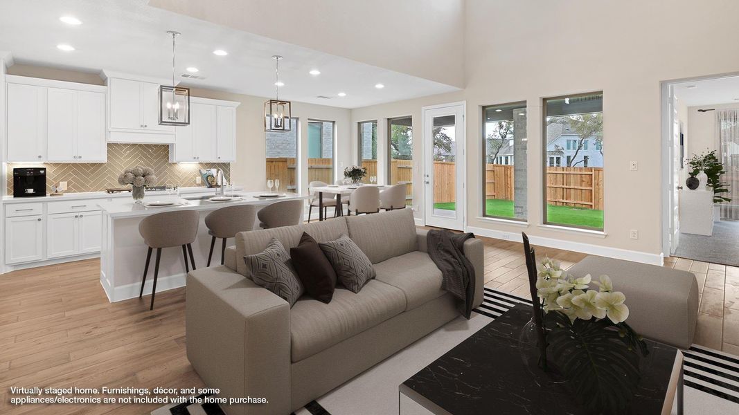 Living room featuring light wood-style floors, recessed lighting, and a high ceiling