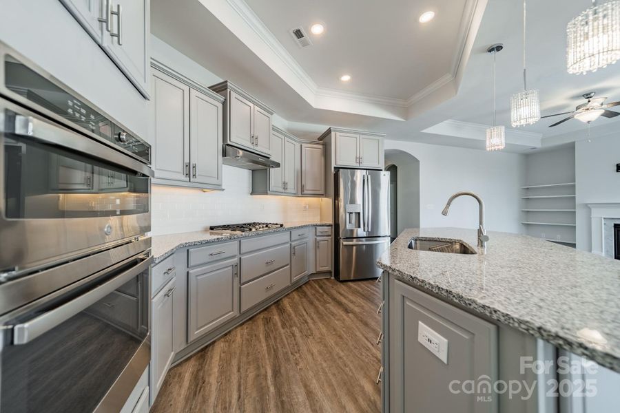 Undermount lighting with tile backsplash and granite countertops