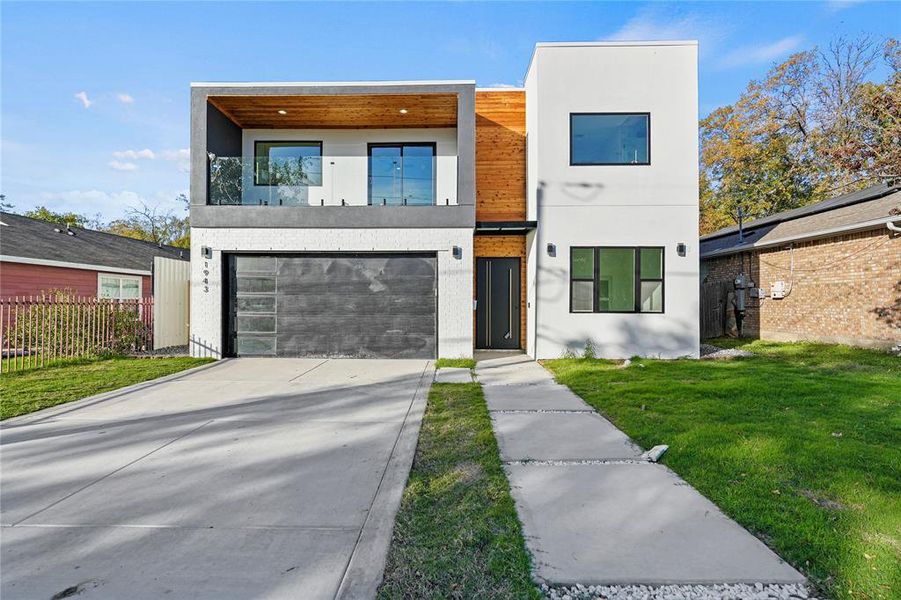 Modern home featuring a garage and a front lawn