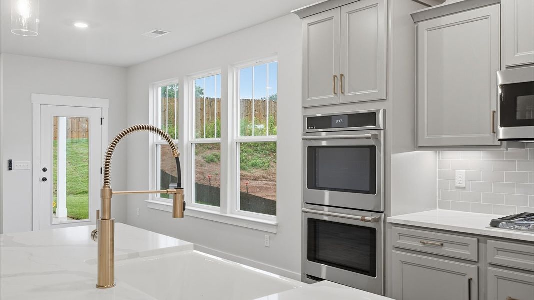 Well-designed kitchen with a center island and tasteful finishes that elevate everyday living Well-designed kitchen with a center island and tasteful finishes that elevate everyday living