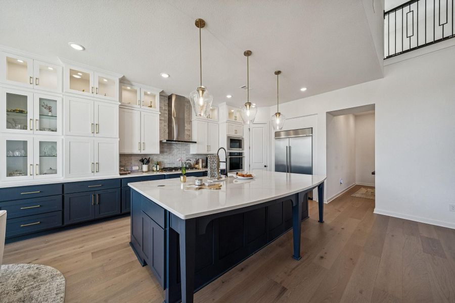 The kitchen is a chef's dream complete with built-in, high-end refrigerator, two-tones cabinets and quartz counters.
