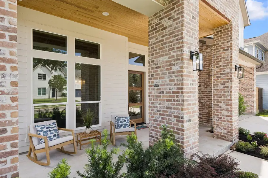 Enjoy a daily dose of Southern charm on this beautifully finished front porch, where classic brick columns, a warm wood slat ceiling and handsome exterior lighting create the perfect perch to enjoy the peaceful neighborhood setting.