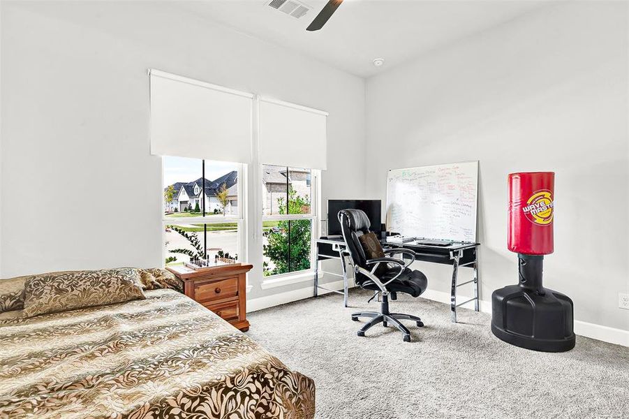 Bedroom featuring a desk, light colored carpet, and ceiling fan