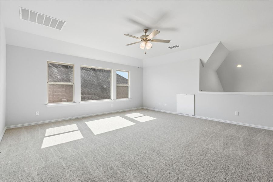 Unfurnished room with ceiling fan, carpet floors, and vaulted ceiling Unfurnished room with ceiling fan, carpet floors, and vaulted ceiling