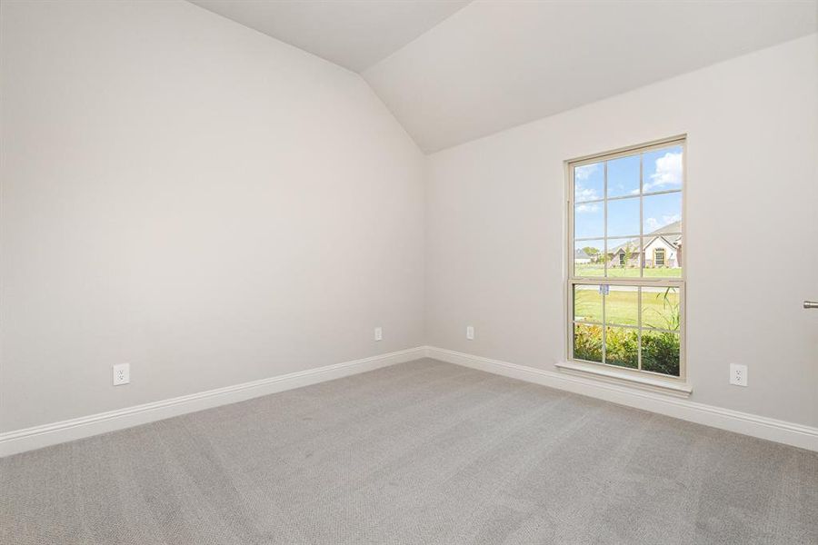 Spare room with light carpet and lofted ceiling Spare room with light carpet and lofted ceiling