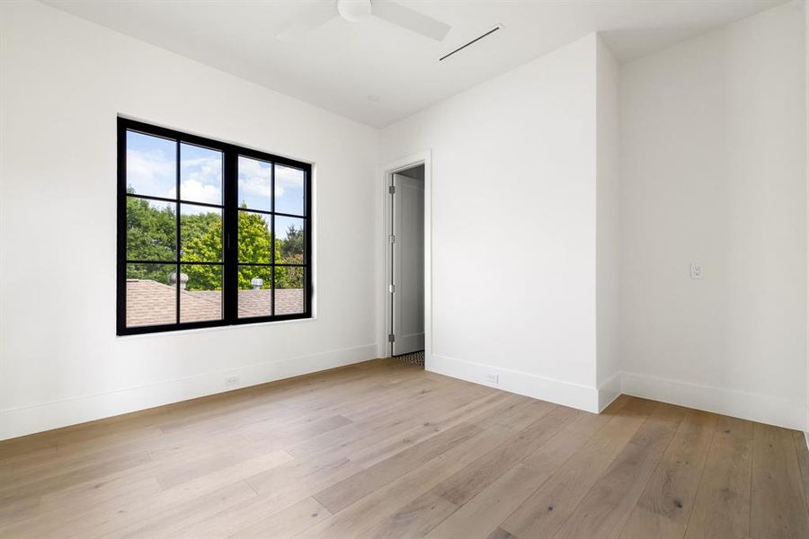 Empty room with light wood-type flooring and ceiling fan Empty room with light wood-type flooring and ceiling fan