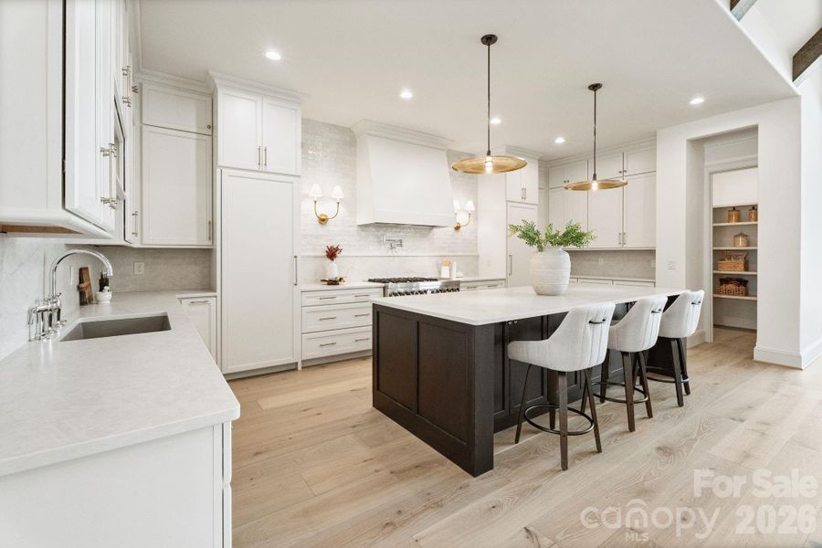 Gourmet kitchen highlighted by quartz counters, spacious island, and huge walk-in pantry