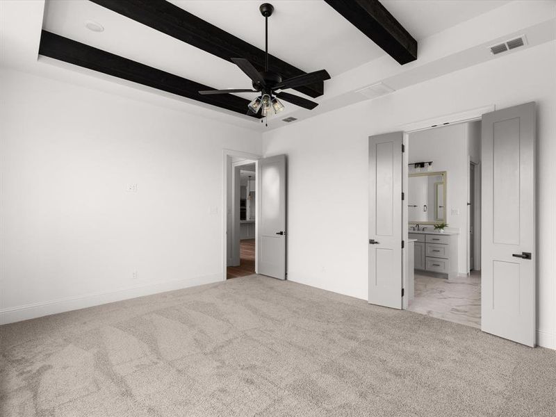 Unfurnished bedroom with light carpet, beam ceiling, ensuite bathroom, and ceiling fan