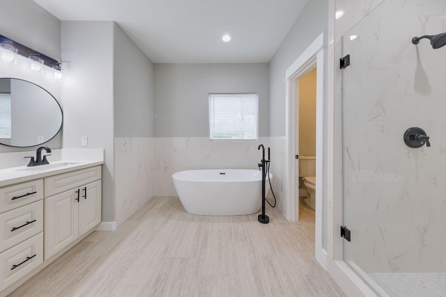 Expansive primary bath with a luxurious soaking tub, dual vanities, and a spacious walk-in shower for ultimate relaxation. Expansive primary bath with a luxurious soaking tub, dual vanities, and a spacious walk-in shower for ultimate relaxation.