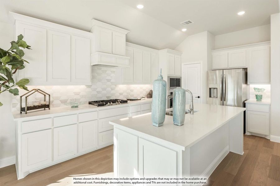 White kitchen with large center island, white cabinets, geometric tile backsplash, and stainless steel appliances