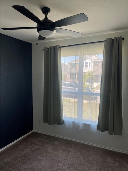 Empty room featuring ceiling fan, carpet flooring, and a textured ceiling Empty room featuring ceiling fan, carpet flooring, and a textured ceiling