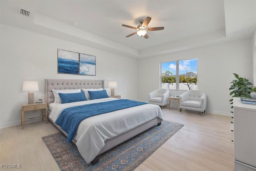 Bedroom with a raised ceiling, light wood-style flooring, and a ceiling fan Bedroom with a raised ceiling, light wood-style flooring, and a ceiling fan