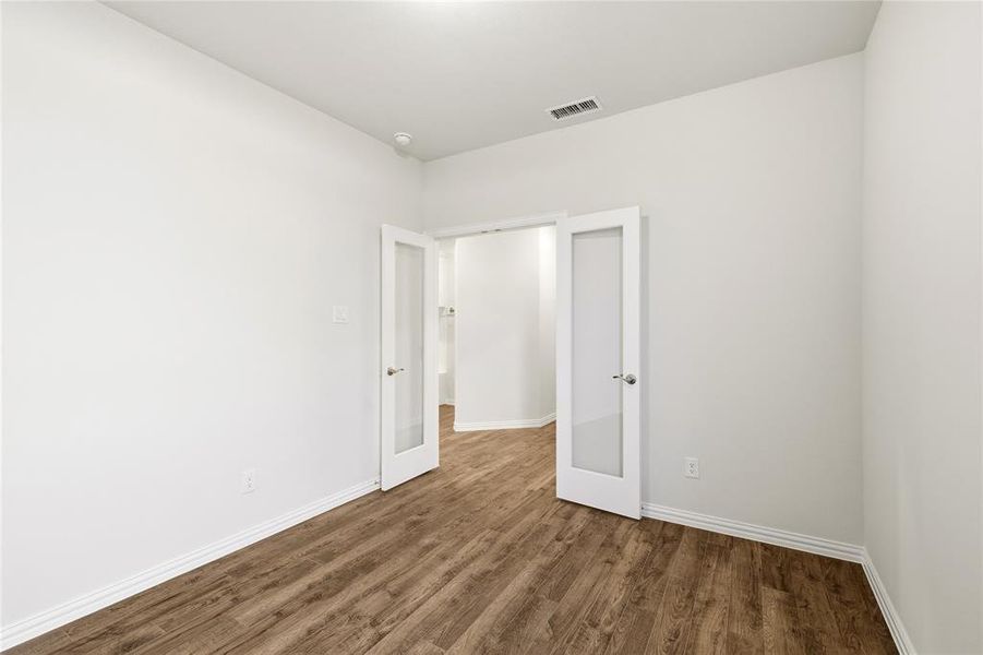 Office with wood laminate flooring.